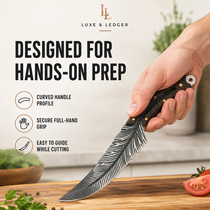 A hand holding a Luxe & Ledger chef's knife with a black feather-patterned handle and a silver blade, positioned over a wooden cutting board with a tomato slice and herbs. The background is a warm, softly blurred kitchen setting with text overlays highlighting the knife's features for hands-on prep.