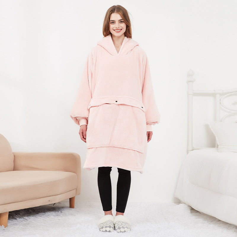 Woman wearing a pink outfit in a minimalistic room with a beige armchair and white sofa.