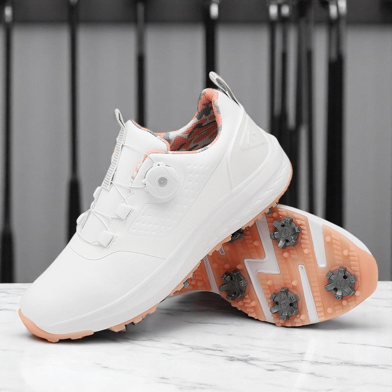 A pair of white golf shoes with a non-slip rubber sole, designed for all-terrain play on a green surface with golf balls and clubs in the background.