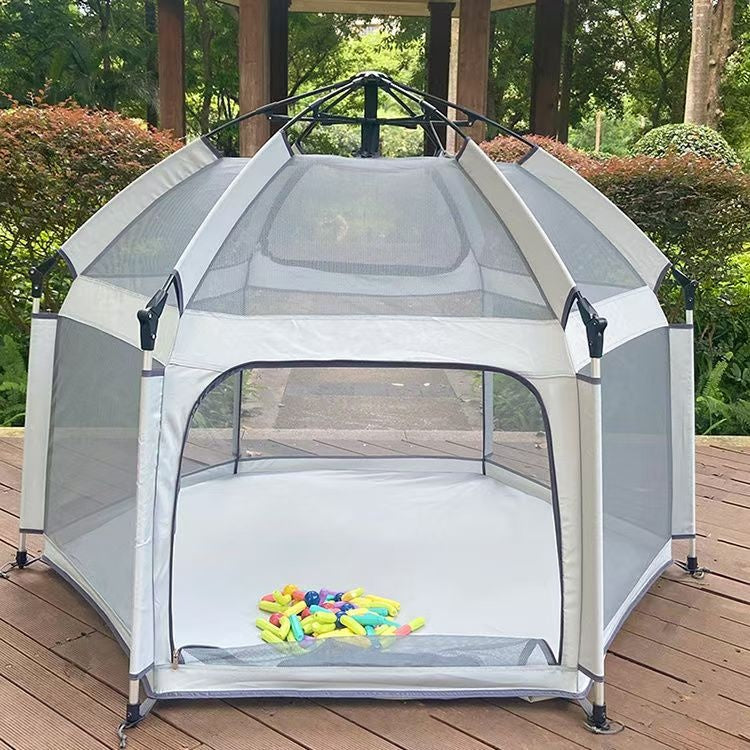 Portable playpen with mesh sides on a wooden deck