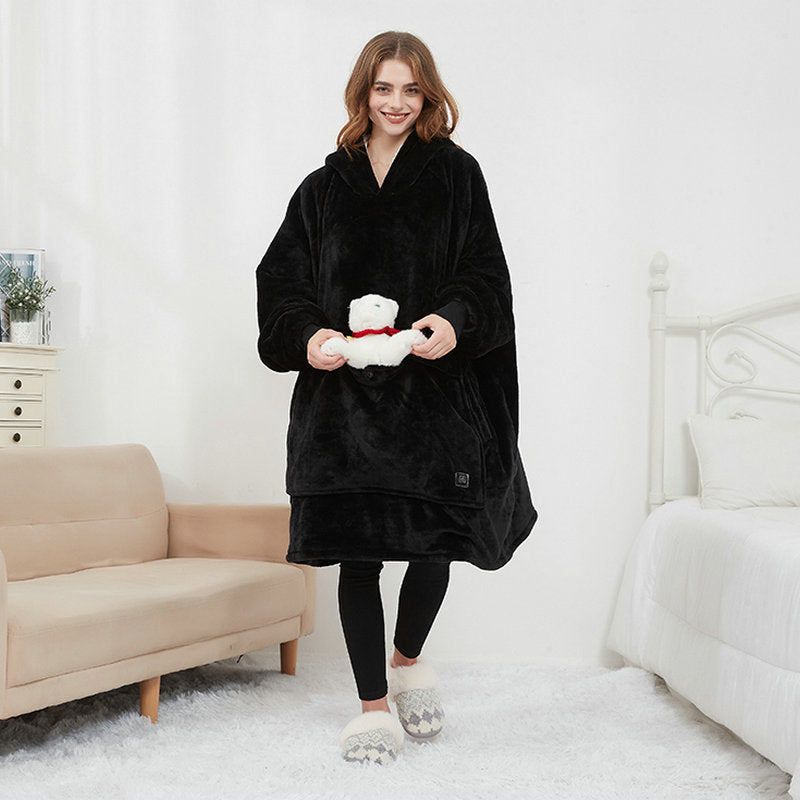 Woman wearing a black robe holding a white teddy bear in a bedroom setting.