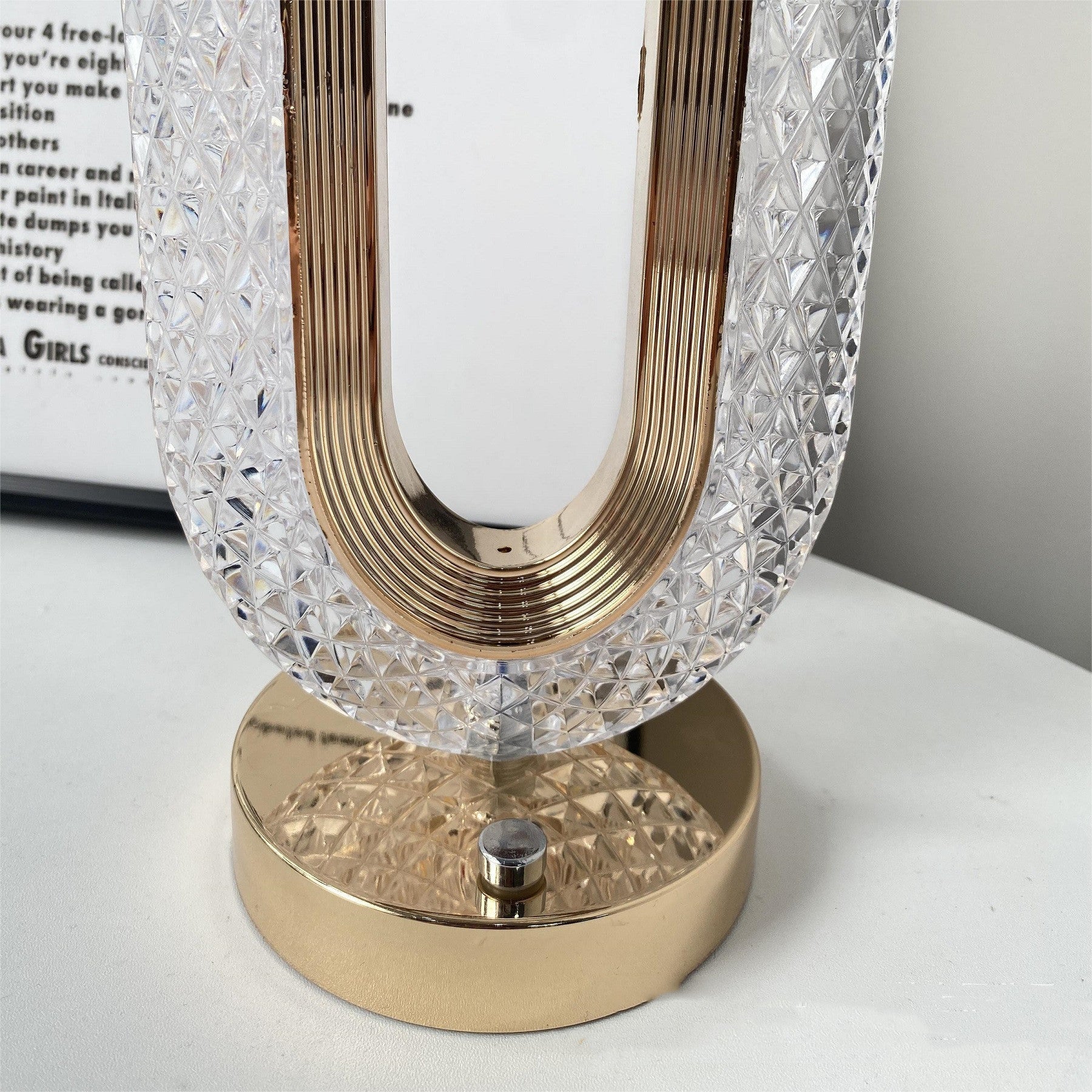 Decorative lamp with crystal shade and gold base on a white surface