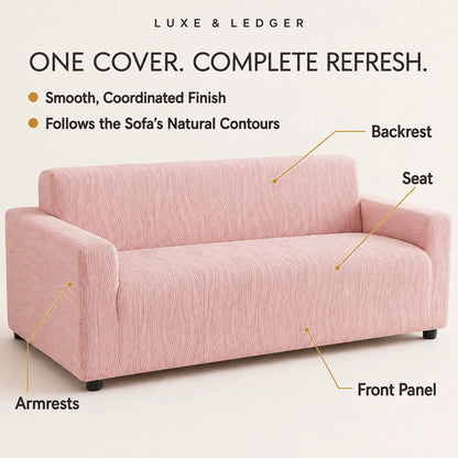 A pink sofa slipcover shown on a sofa, with callout labels pointing to the backrest, seat, armrests, and front panel. Text at the top reads 'LUXE & LEDGER' and 'ONE COVER.