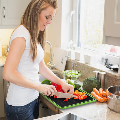 Woman cutting vegetables on a green cutting board in a kitchen.