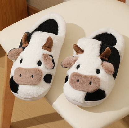 Pair of cow-themed slippers on a chair