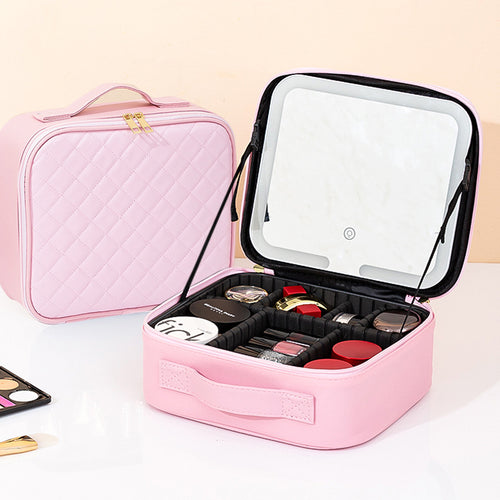 Pink makeup case with mirror and cosmetics on a light background