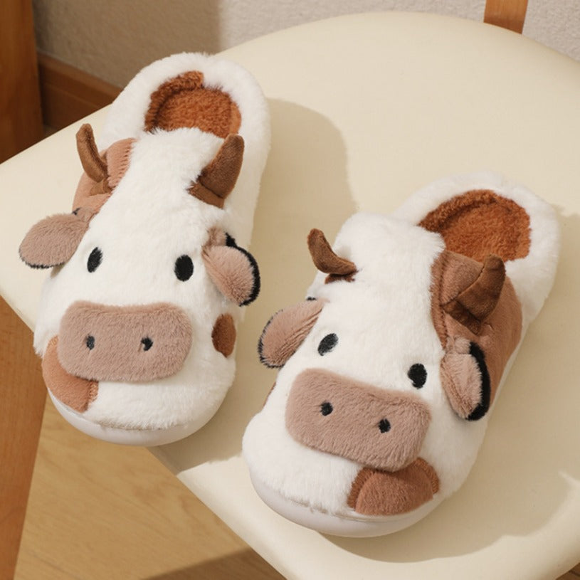 Pair of cow-themed slippers on a chair