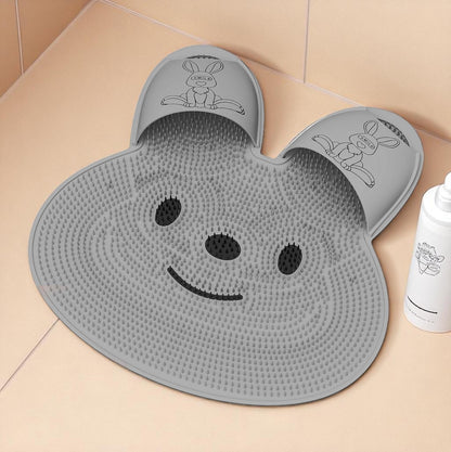 Gray bath mat shaped like a smiling face with cartoon characters on a tiled floor.