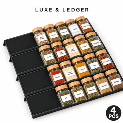 Four black spice jar organizers arranged in a grid, each holding clear glass spice jars with tan lids and labeled spices, shown on a white background with the text 'LUXE & LEDGER' and a '4 PCS' badge.