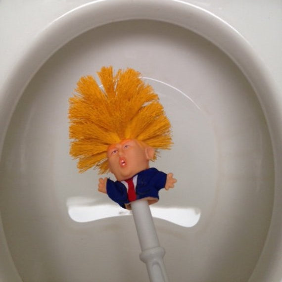 Toilet brush with a character head on top of a toilet