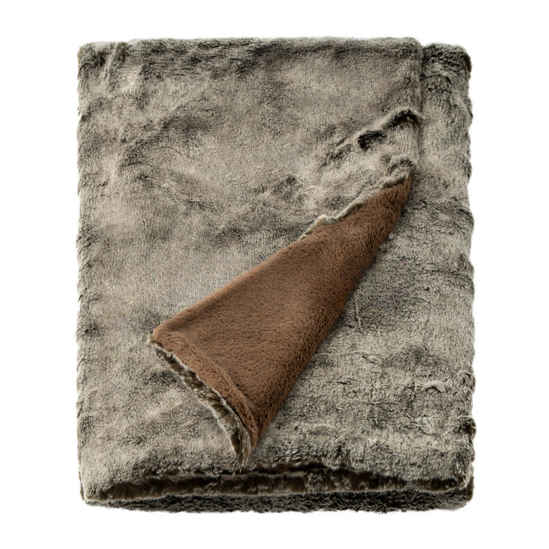Folded textured blanket with a brown corner on a white background