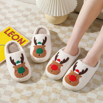 Pair of cartoon reindeer slippers on a checkered floor with a book titled 'LEON' in the background.