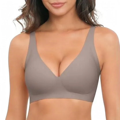 A woman wearing a seamless, scoop-neck bralette in a muted taupe-brown color, shown from the chest up against a plain white background.
