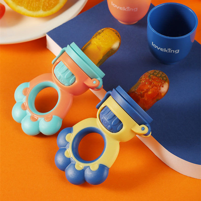 Colorful baby teething toys with fruits on a blue tray and orange surface.
