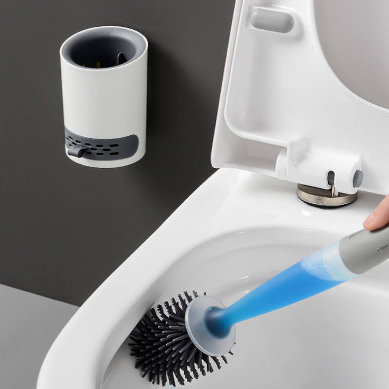 Toilet cleaning brush with holder attached to a toilet bowl.
