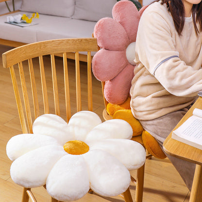 Flower-shaped cushions on a chair with a person sitting nearby in a home setting.