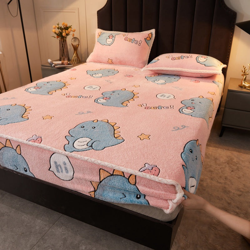 Bed with pink cartoon-patterned bedspread and matching pillows in a bedroom setting.