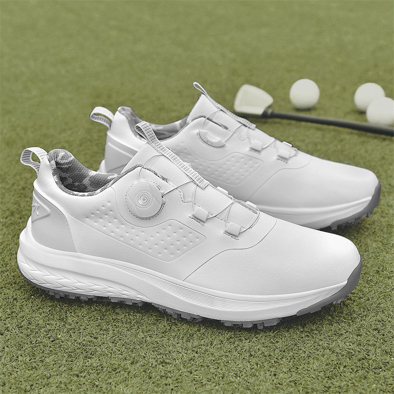 A pair of white golf shoes with a non-slip rubber sole, designed for all-terrain play on a green surface with golf balls and clubs in the background.