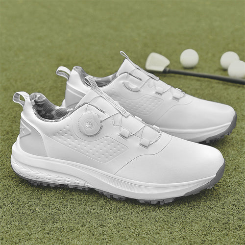 A pair of white golf shoes with a non-slip rubber sole, designed for all-terrain play on a green surface with golf balls and clubs in the background.