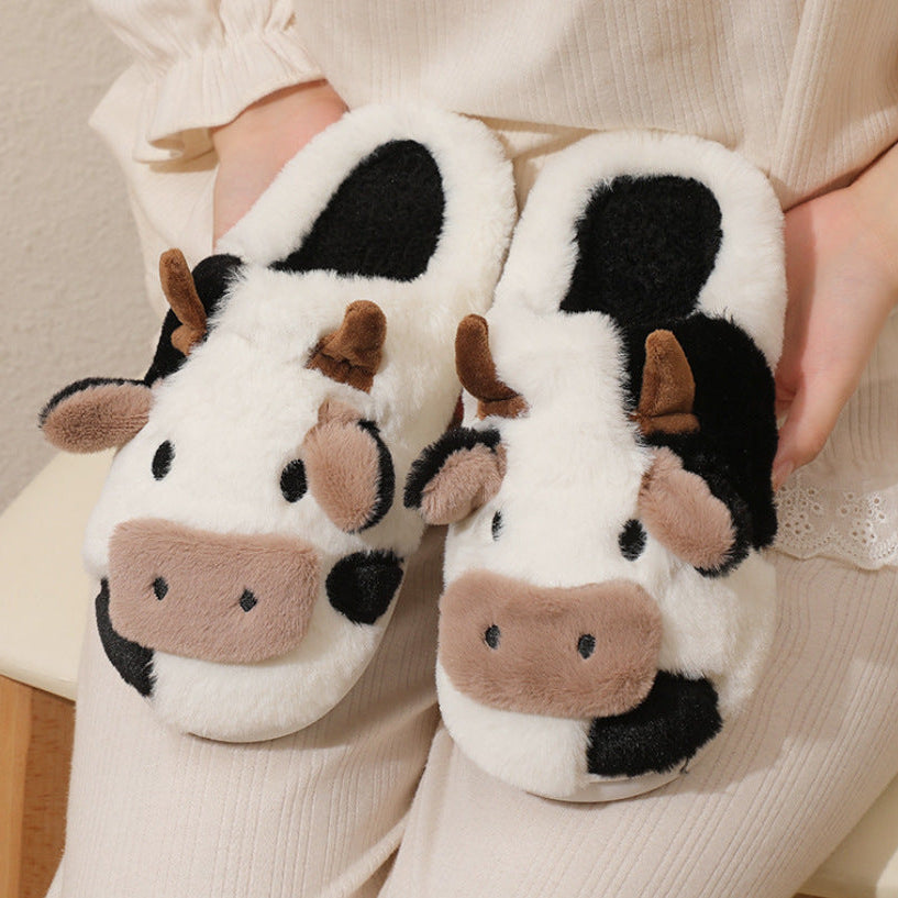 Cow-themed slippers worn by a person sitting on a chair.