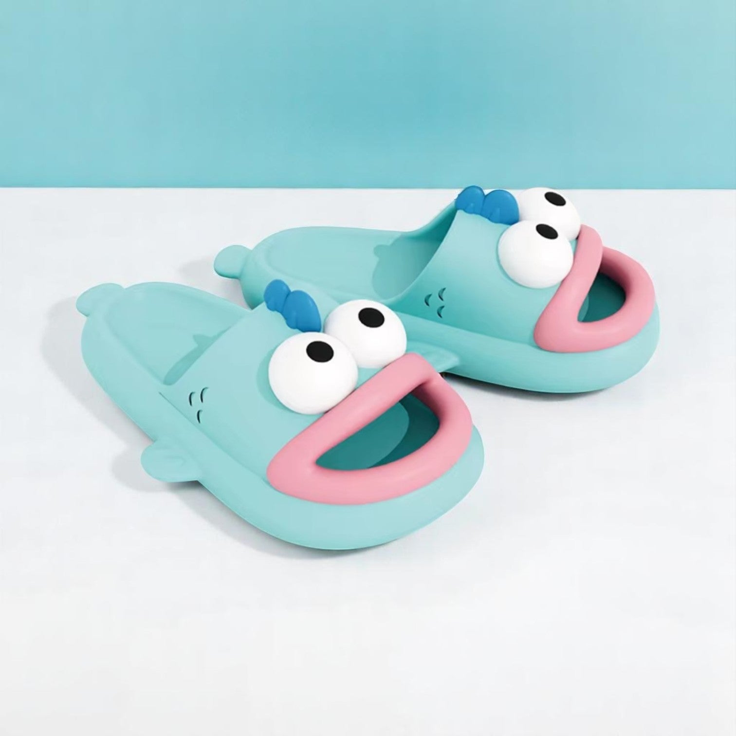 A pair of blue EVA slippers designed to resemble a cartoon character, with large eyes and a happy expression.