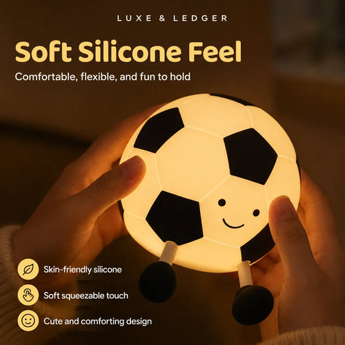 A person holds a soccer-ball-shaped night light with a warm glowing face. The image includes marketing text reading 'LUXE & LEDGER' and 'Soft Silicone Feel' with feature callouts like skin-friendly silicone, soft squeezable touch, and cute comforting design.