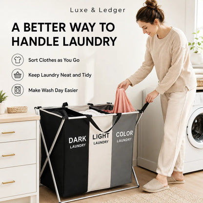 A woman in beige loungewear is shown using a foldable laundry hamper in a bright laundry room. The hamper has three color-coded sections labeled 'DARK LAUNDRY', 'LIGHT LAUNDRY', and 'COLOR LAUNDRY' on a black and white striped design.