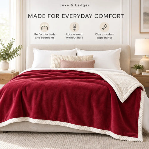 A plush bed in a bright bedroom setting with a deep red fleece blanket featuring a cream sherpa lining and braided border, styled with white and beige pillows. Text above reads 'Luxe & Ledger MADE FOR EVERYDAY COMFORT' with three feature icons.