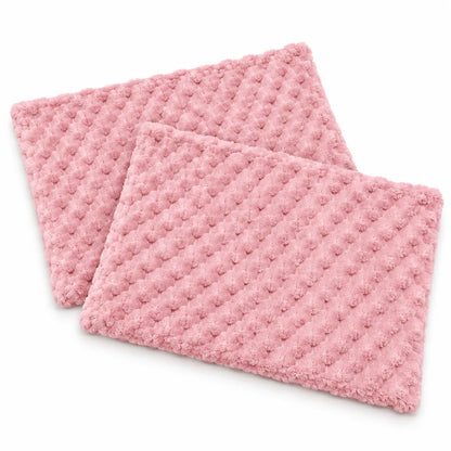 Two pink textured rectangular mats with a raised waffle or bumpy dot pattern, shown overlapping on a clean white background.