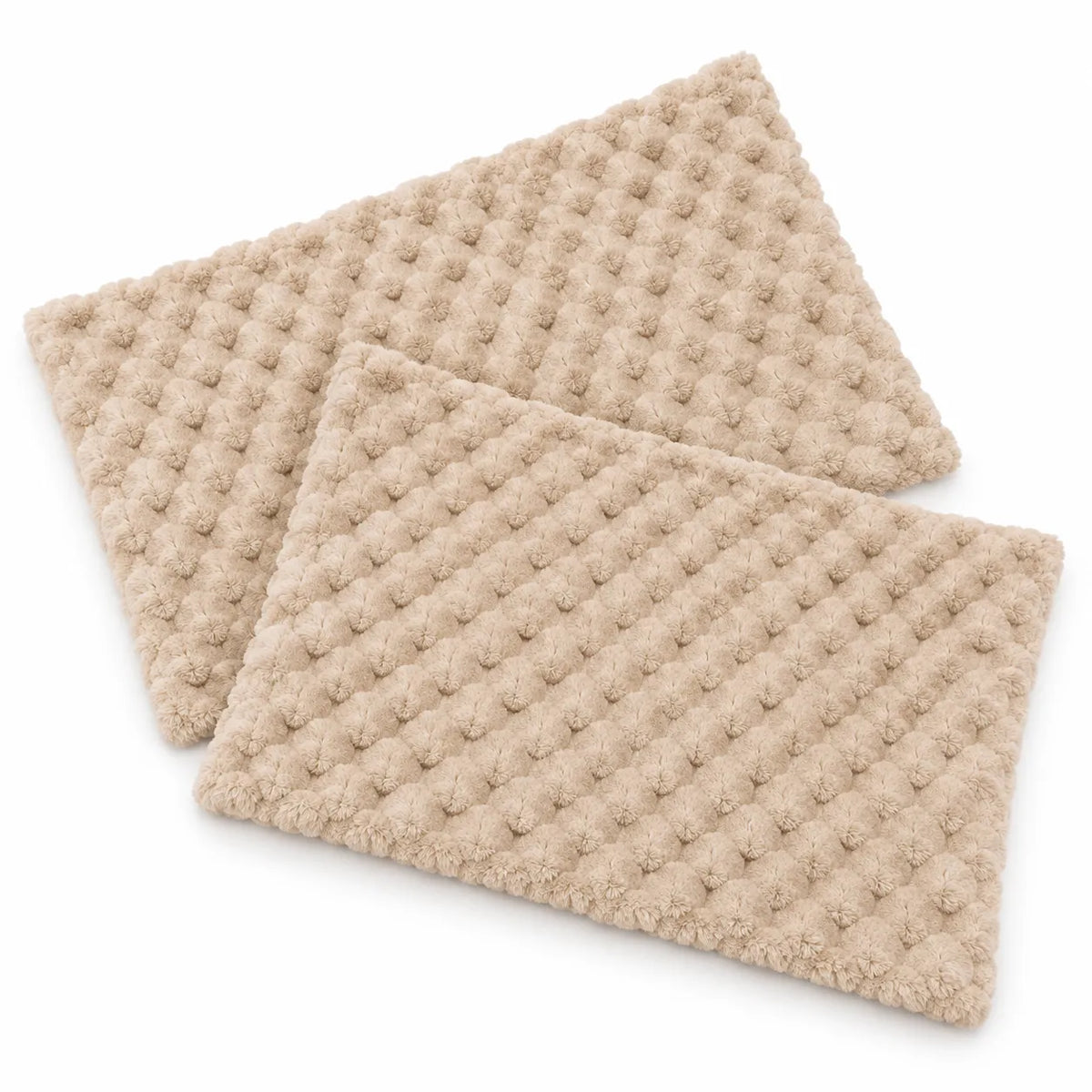 Two beige textured rectangular mats with a raised waffle or bumpy dot pattern, shown overlapping on a clean white background.