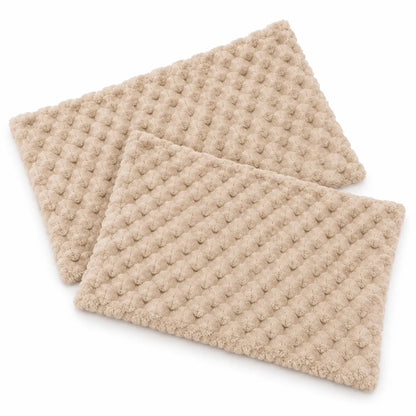 Two beige textured rectangular mats with a raised waffle or bumpy dot pattern, shown overlapping on a clean white background.