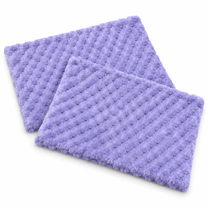 Two lavender purple textured bath mats with a raised dotted diamond pattern, shown overlapping on a clean white background.