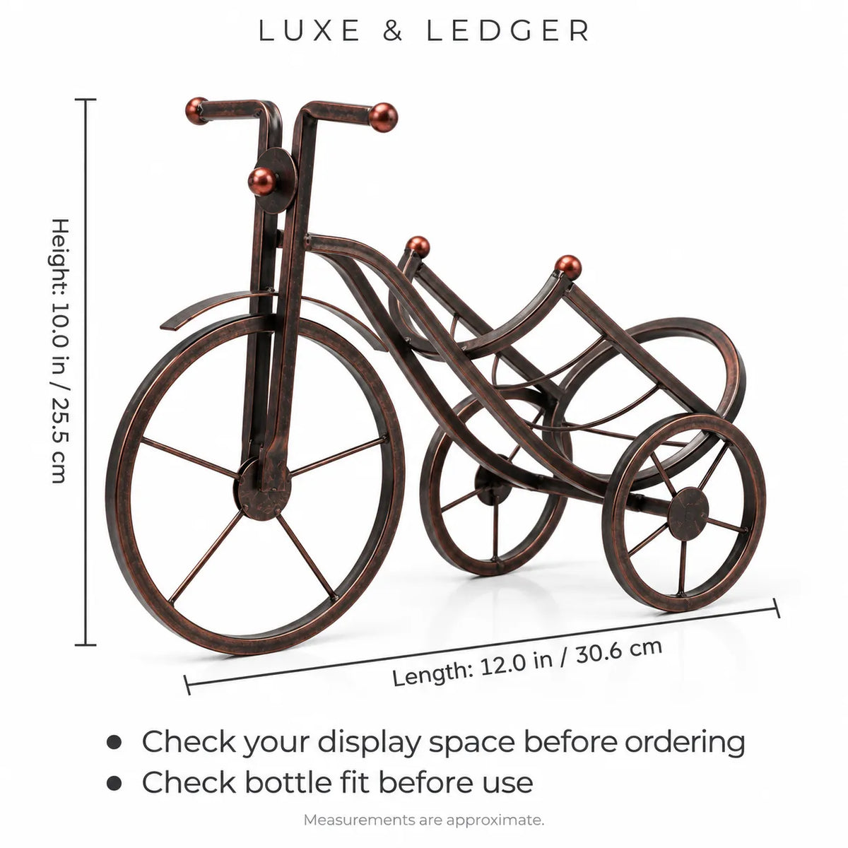 A decorative metal tricycle-style bottle holder with a dark bronze finish and copper-toned accents, shown with dimension lines indicating height 10.0 in (25.