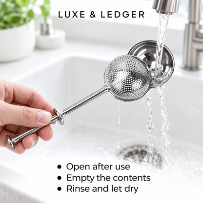 A hand holds a stainless steel tea infuser strainer with a long handle over a white kitchen sink, with water running from a faucet. Text on the image reads 'LUXE & LEDGER' and 'Open after use Empty the contents Rinse and let dry'.