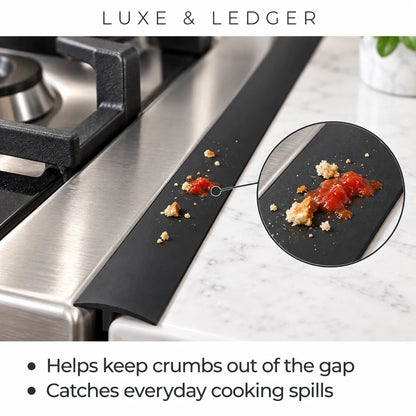 A black kitchen spill-catching strip placed in the gap between a stainless steel gas stove and a white marble countertop. The image includes a circular inset showing food crumbs on the strip, with text at the top reading 'LUXE & LEDGER' and bullet points below describing its spill-catching benefit.