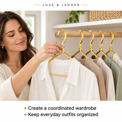 A woman hangs a white blouse on a gold hanger in a closet, with several coordinated garments on a wooden rod. Text at the top reads 'LUXE & LEDGER,' and text at the bottom says 'Create a coordinated wardrobe' and 'Keep everyday outfits organized.
