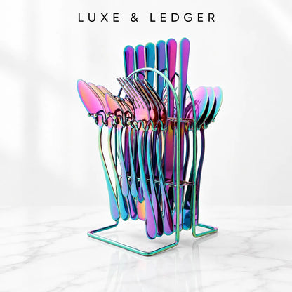 A set of iridescent rainbow-colored stainless steel cutlery, including forks, spoons, and knives, displayed in a matching metal stand on a white marble surface. The brand name 'LUXE & LEDGER' is printed in black at the top of the image.
