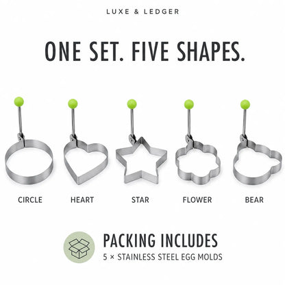 Luxe & Ledger stainless steel egg molds set with five shapes: circle, heart, star, flower, and bear, each with a green top loop, shown on a white background with text indicating one set, five shapes, and packing includes 5 stainless steel egg molds.