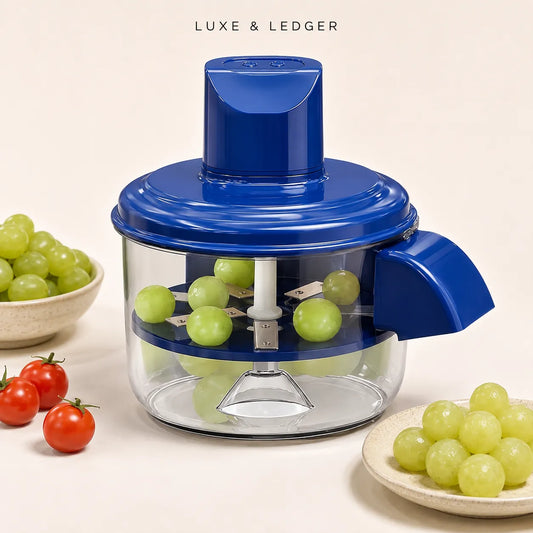 A blue and clear food chopper with green grapes inside, styled on a light beige background with tomatoes and more grapes on plates. The text 'LUXE & LEDGER' is visible at the top.