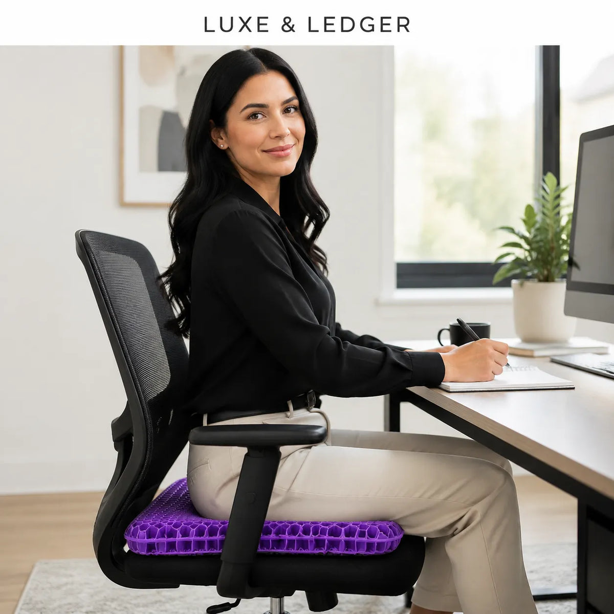 A woman sits in a black mesh office chair wearing a purple gel lumbar support cushion, positioned at a desk in a bright home office. The brand name 'LUXE & LEDGER' is displayed at the top of the image.
