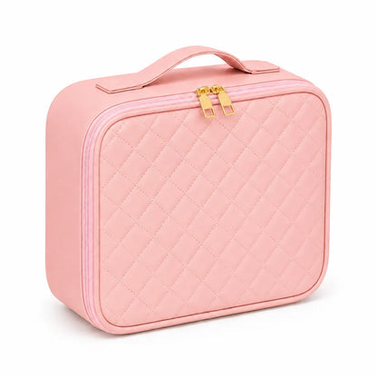 A light pink quilted cosmetic case with a top handle and gold-tone zipper pulls, shown on a clean white background.