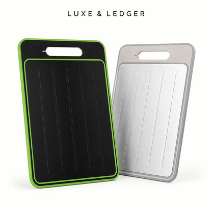 Two rectangular cutting boards with integrated handles are shown on a clean white background. The front board is black with a bright green border, and the rear board is silver with a gray border.