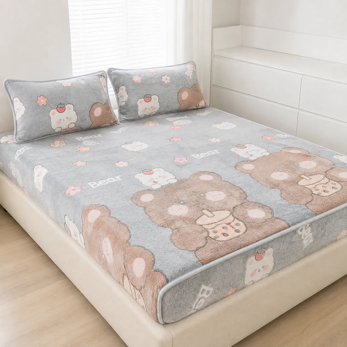 A plush gray bed sheet set with matching pillowcases, featuring a cute teddy bear and white bear pattern, styled on a bed in a bright, modern bedroom.