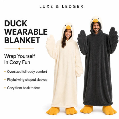 Two models wearing plush duck wearable blankets, one in cream and one in dark gray, with yellow beaks and feet, on a white background with promotional text.