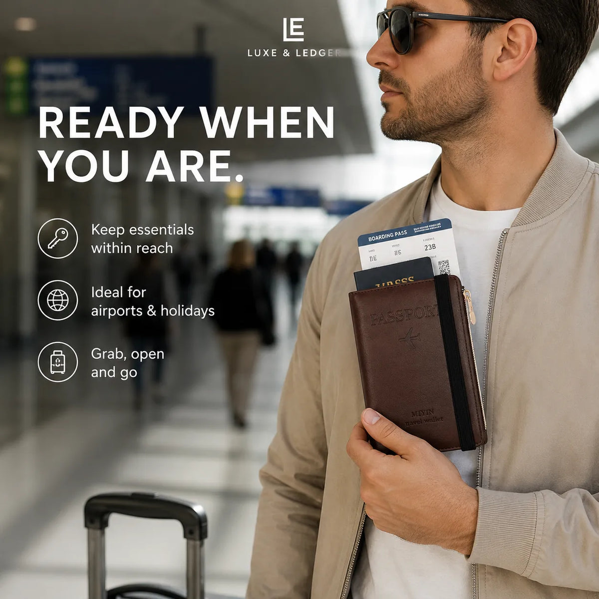 A man in a beige bomber jacket and sunglasses stands in an airport holding a brown leather passport holder with boarding passes, next to a rolling suitcase. Large text on the left reads 'READY WHEN YOU ARE.