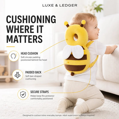 A baby wearing a yellow and brown bee-shaped backpack cushion protector in a bright living room. The image includes text and callout lines explaining the product features: head cushion, padded back, and secure straps.