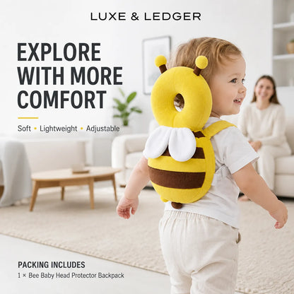 A toddler wearing a plush bee backpack in a bright, modern living room. The backpack is yellow and brown with white wings and a soft head protector.