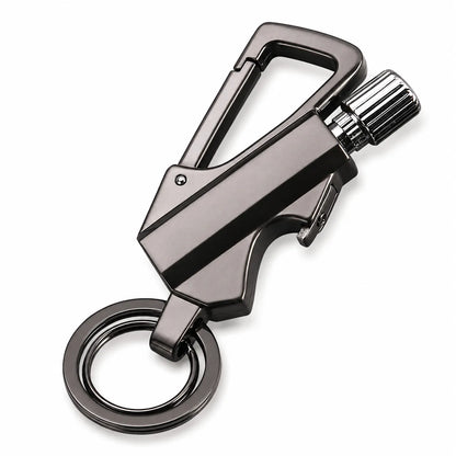 A black metallic personal safety keychain tool with a carabiner clip, textured dial, and split key ring, shown on a white background.