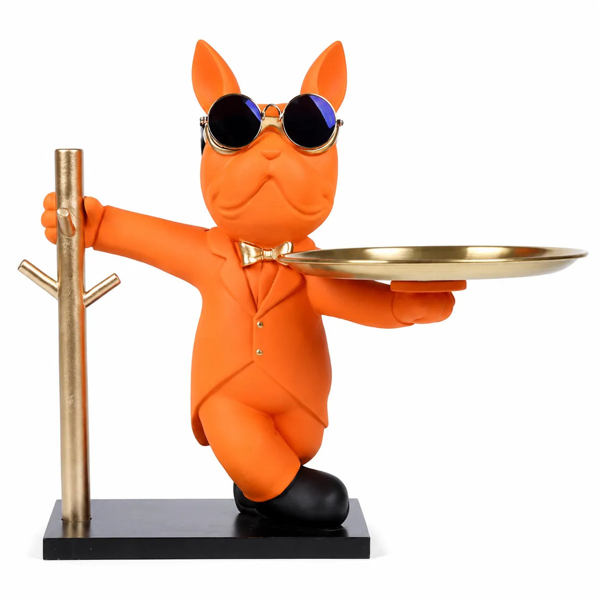 An orange cat figurine wearing a matching orange suit, sunglasses, and a bow tie, holding a round gold tray while standing on a black base next to a gold tree stand, on a white background.