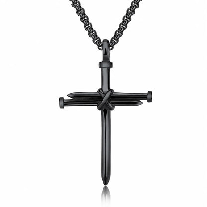 A black cross pendant necklace featuring a central crucifix design with nails, suspended from a matching black chain on a white background.